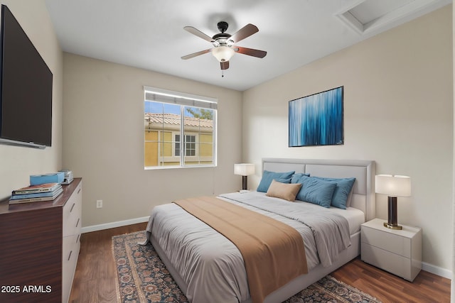 bedroom with ceiling fan, wood finished floors, attic access, and baseboards