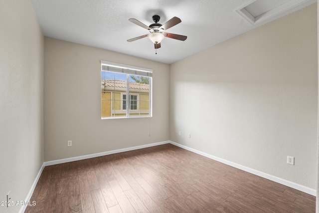 unfurnished room with attic access, ceiling fan, a textured ceiling, wood finished floors, and baseboards