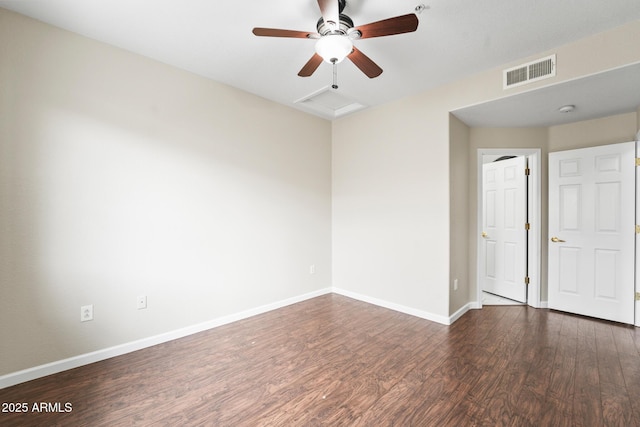 empty room with baseboards, wood finished floors, visible vents, and attic access