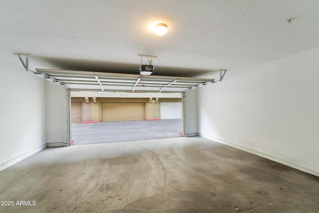 garage with baseboards and a garage door opener