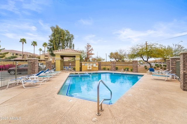 pool with a patio area and fence