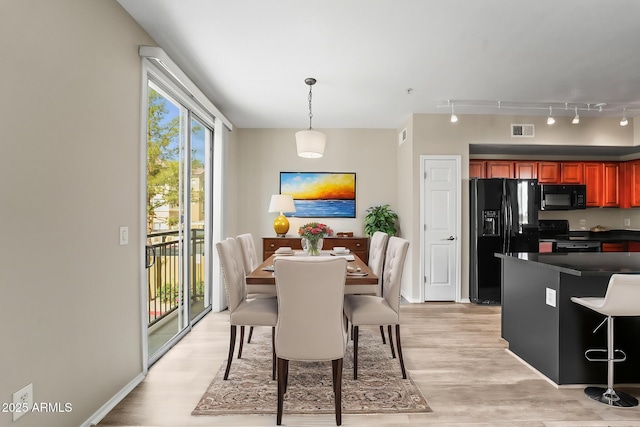 dining area featuring baseboards, light wood-style flooring, visible vents, and track lighting