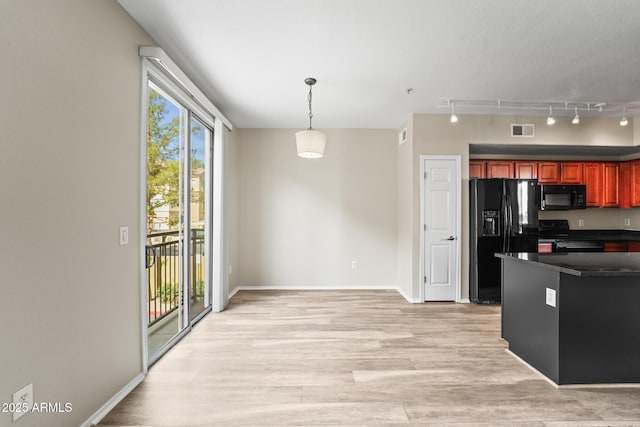 kitchen featuring visible vents, dark countertops, light wood-style flooring, hanging light fixtures, and black appliances