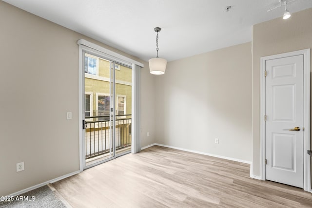 unfurnished room with light wood-style floors and baseboards