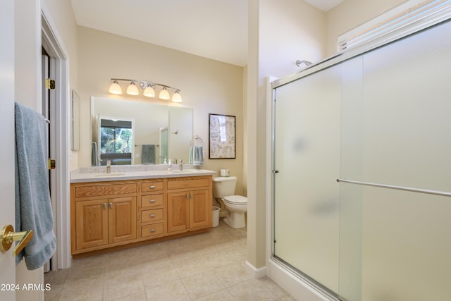 bathroom with tile patterned floors, vanity, toilet, and walk in shower