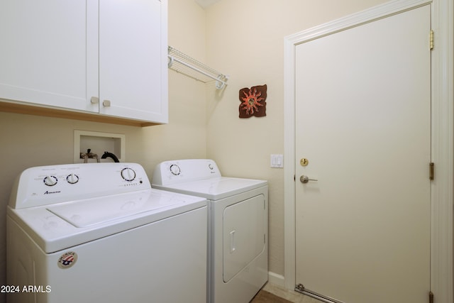 clothes washing area featuring cabinets and washing machine and dryer