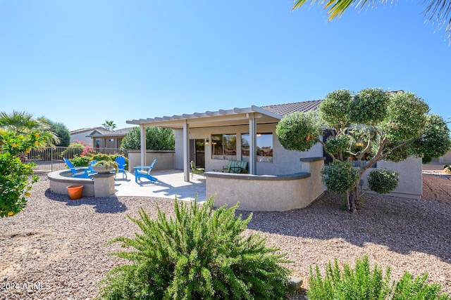 rear view of house featuring a patio area and an outdoor fire pit