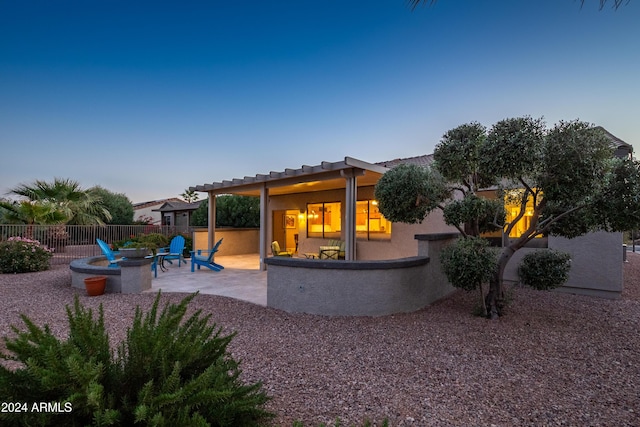 rear view of house with a fire pit and a patio