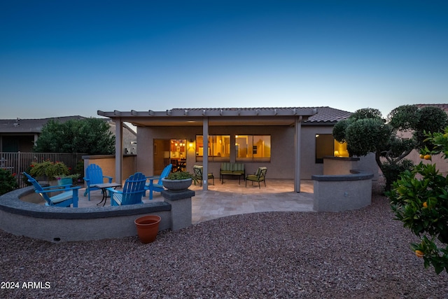 back of property with a patio and a fire pit