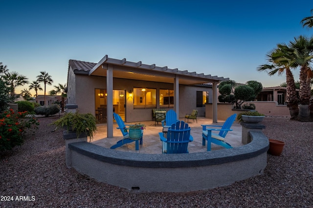 back house at dusk with a patio area