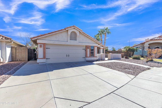 view of front facade featuring driveway, a tiled roof, an attached garage, fence, and stucco siding