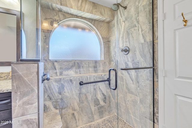 bathroom with a shower stall and vanity