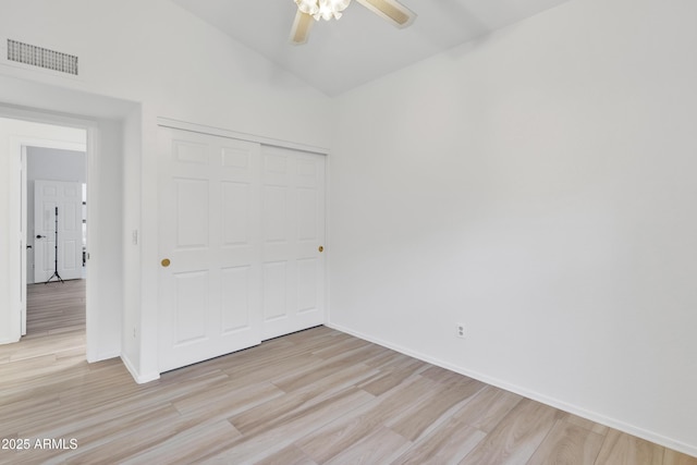 unfurnished bedroom with baseboards, a closet, visible vents, and wood finished floors