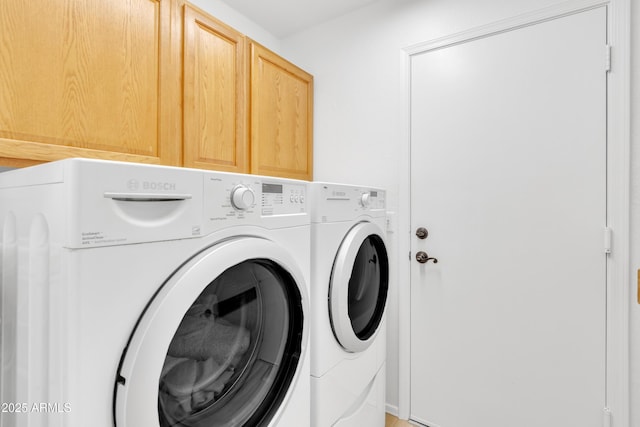 washroom featuring cabinet space and washing machine and clothes dryer