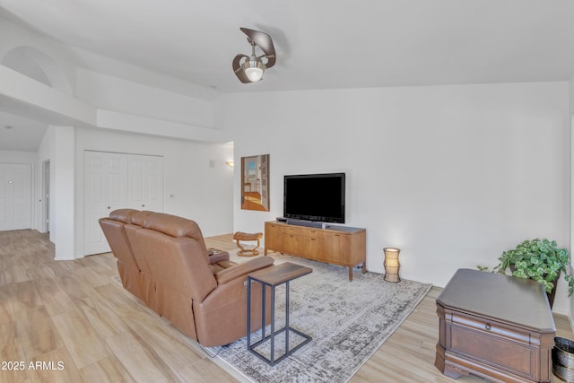 living room featuring lofted ceiling and light wood-style flooring