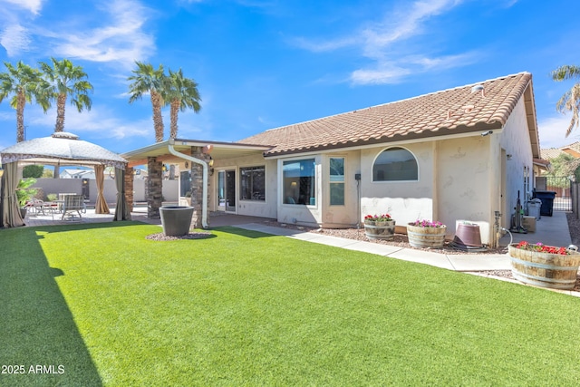 back of house with a tile roof, fence, a gazebo, a yard, and a patio area