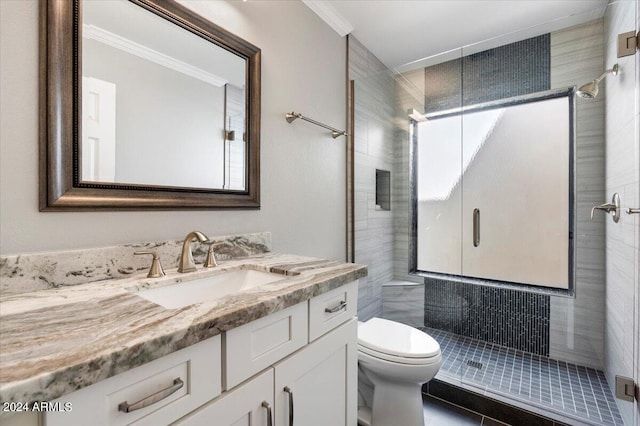 bathroom featuring vanity, crown molding, toilet, and a shower with door