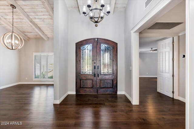 entrance foyer with ceiling fan with notable chandelier, beamed ceiling, french doors, and dark hardwood / wood-style flooring