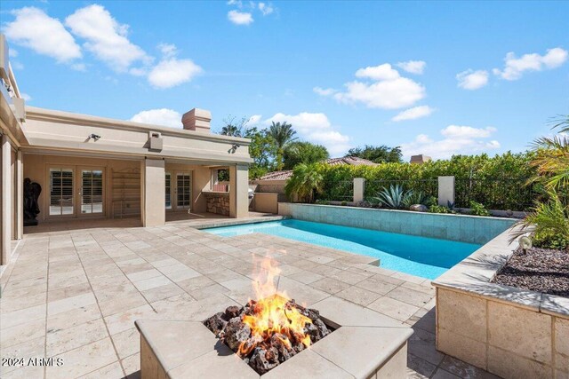 view of pool with a patio and a fire pit