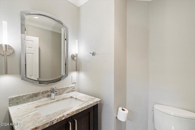 bathroom featuring ornamental molding, vanity, and toilet