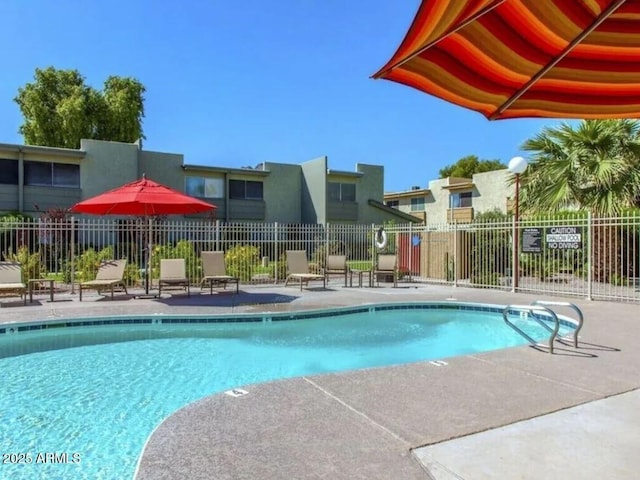 community pool featuring a patio area and fence