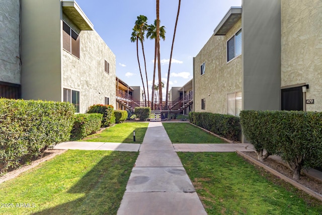 surrounding community featuring a lawn and stairway