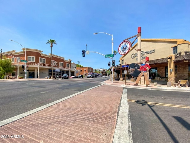 view of street featuring sidewalks, traffic lights, street lighting, and curbs