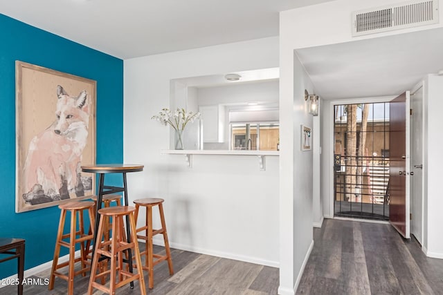 interior space featuring wood finished floors, visible vents, and baseboards