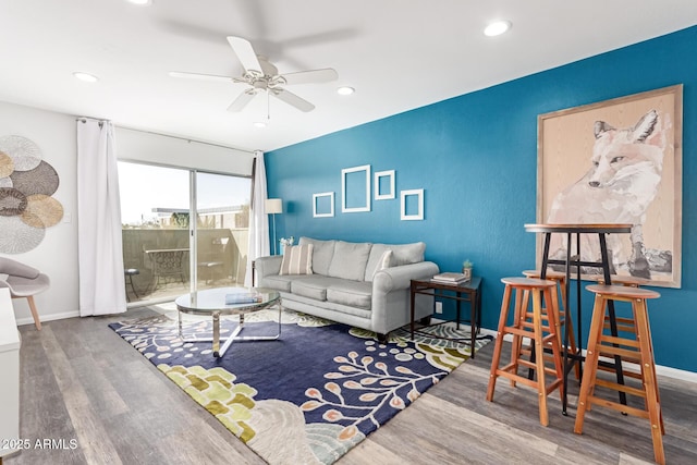 living room with recessed lighting, baseboards, and wood finished floors