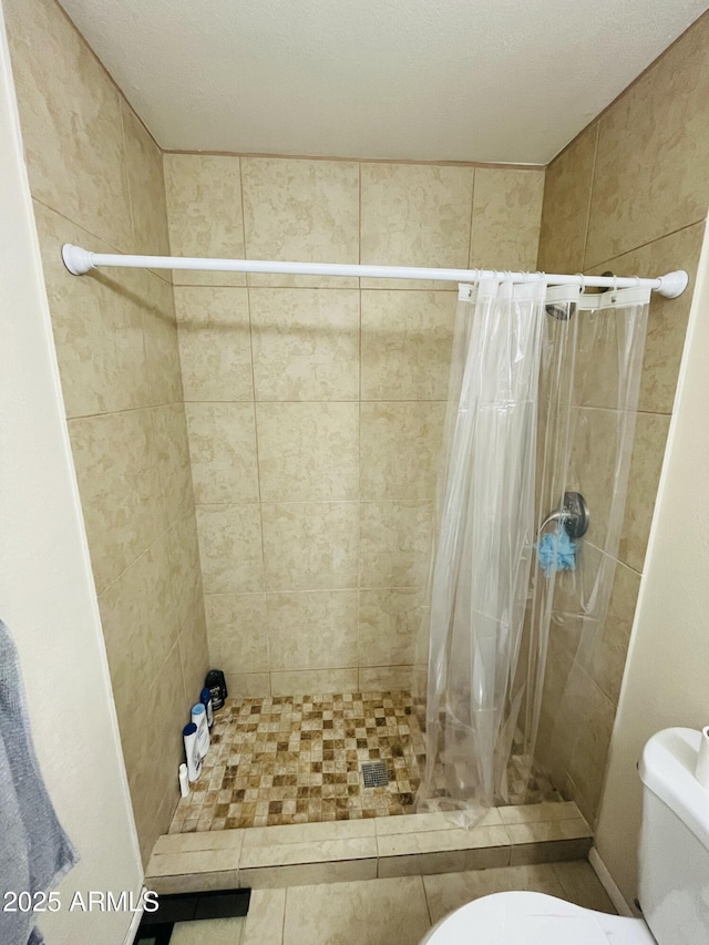 full bathroom featuring a shower stall and toilet