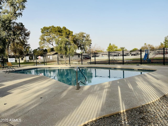 community pool with fence and a patio