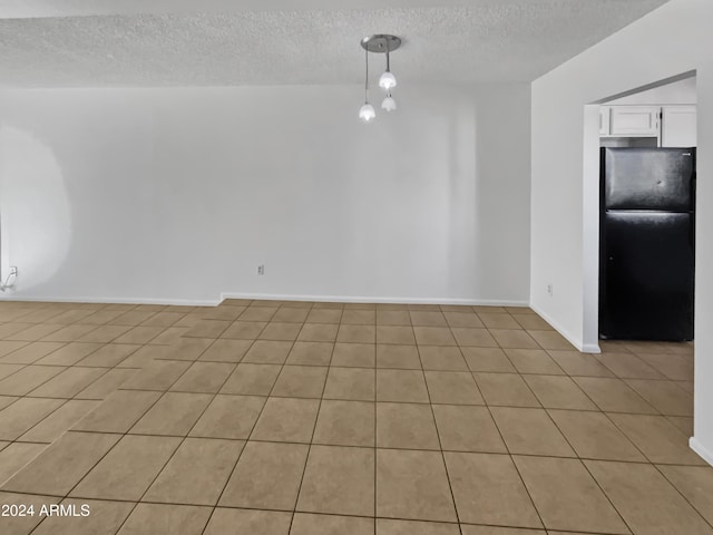 unfurnished room featuring light tile patterned floors and a textured ceiling