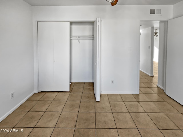 unfurnished bedroom featuring light tile patterned flooring and a closet