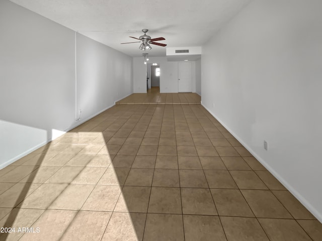 spare room featuring tile patterned floors and ceiling fan