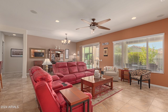 tiled living room with ceiling fan with notable chandelier