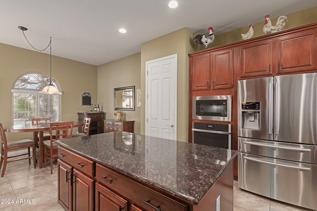 kitchen featuring appliances with stainless steel finishes, light tile patterned floors, a kitchen island, and dark stone countertops