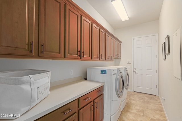 laundry room featuring separate washer and dryer, light tile patterned floors, and cabinets