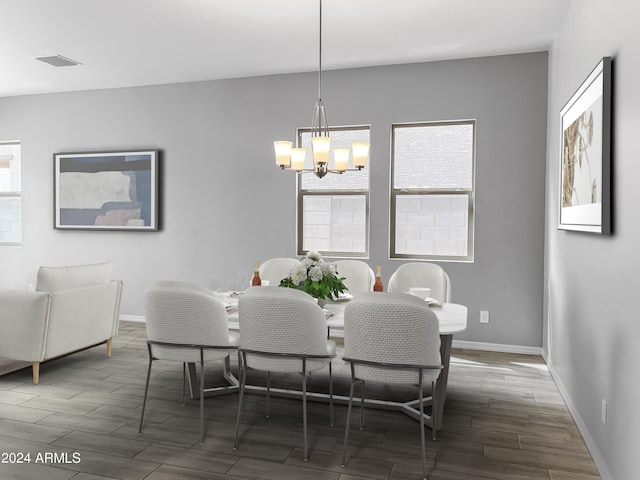 dining room featuring wood tiled floor, visible vents, baseboards, and an inviting chandelier