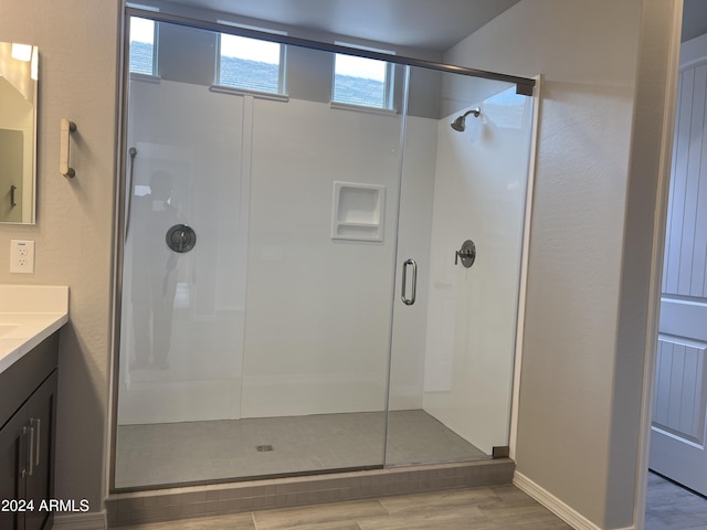 bathroom featuring a shower stall, wood finished floors, and vanity