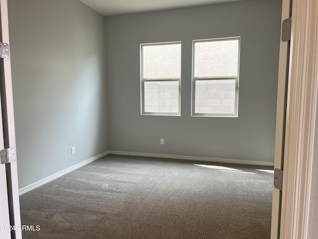 carpeted spare room with baseboards