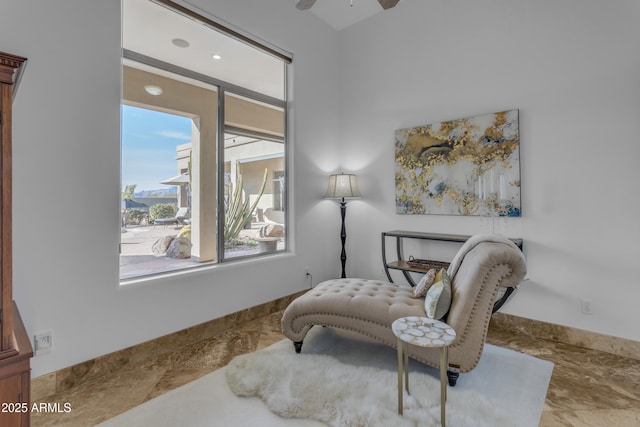 sitting room with a ceiling fan and baseboards