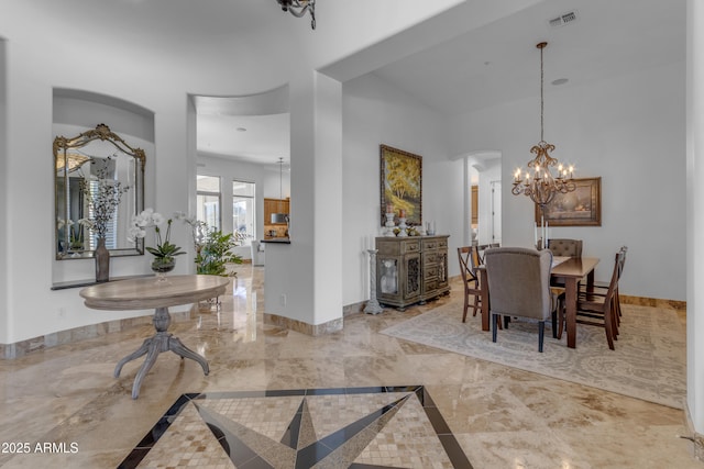 dining room with arched walkways, marble finish floor, a notable chandelier, visible vents, and baseboards