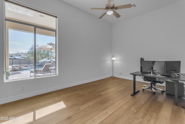 office area with baseboards, ceiling fan, visible vents, and light wood finished floors