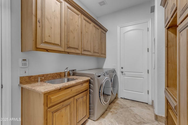 laundry area featuring visible vents, separate washer and dryer, a sink, and cabinet space