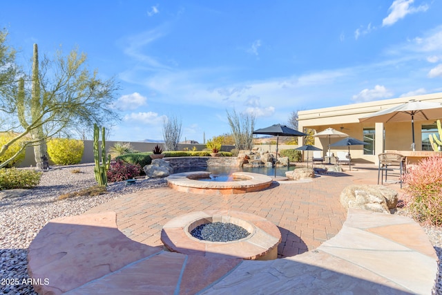 view of patio with fence and a fire pit