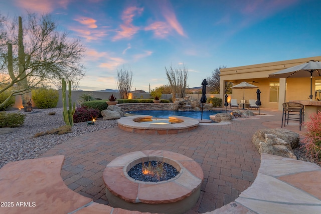 view of swimming pool featuring a fire pit, exterior bar, and a patio area