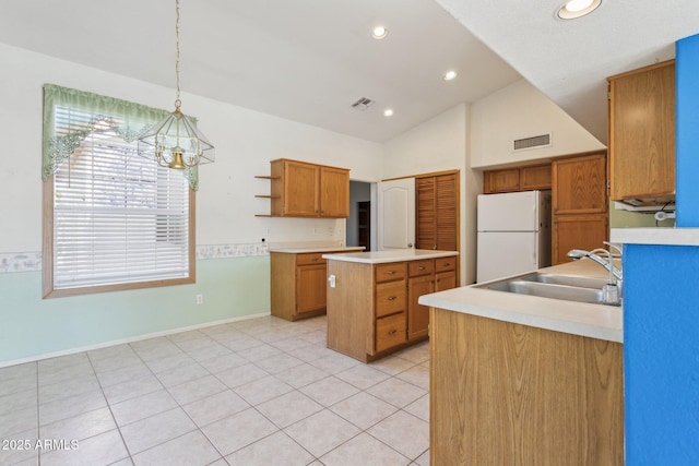 kitchen with sink, vaulted ceiling, a center island with sink, white refrigerator, and pendant lighting