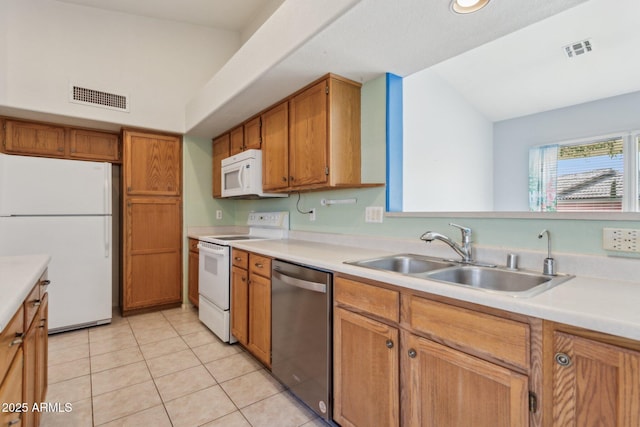 kitchen with white appliances, sink, and light tile patterned floors