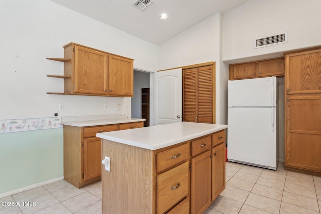 kitchen with white refrigerator, a kitchen island, light tile patterned floors, and high vaulted ceiling