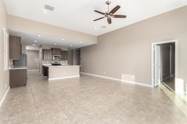 unfurnished living room with sink, ceiling fan, and light tile patterned flooring